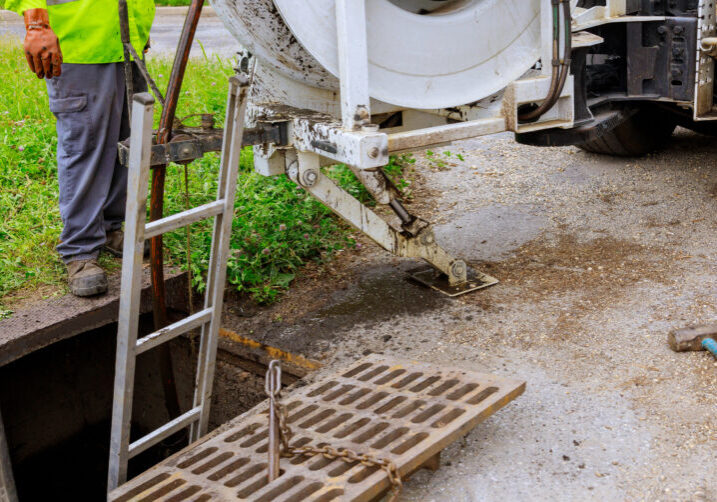 Sewage cleaning workers equipment with sewer on a town street on industrial truck