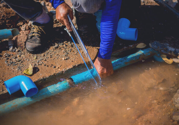 Construction worker,Repairing a broken water pipe on the concrete road.